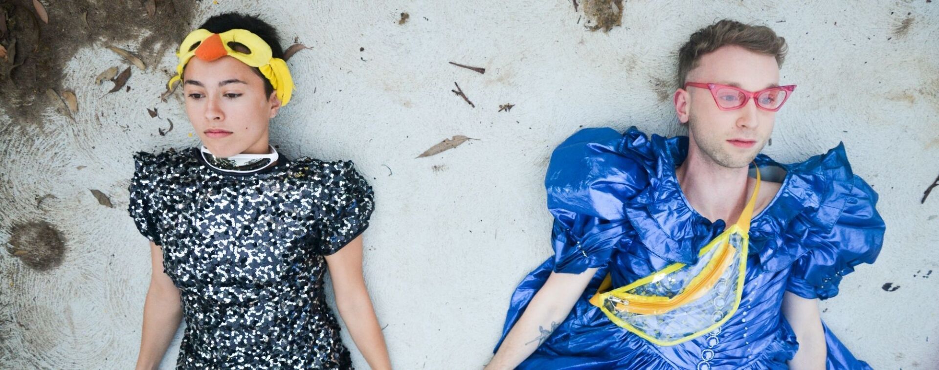 Two dancers lying on the ground in costume